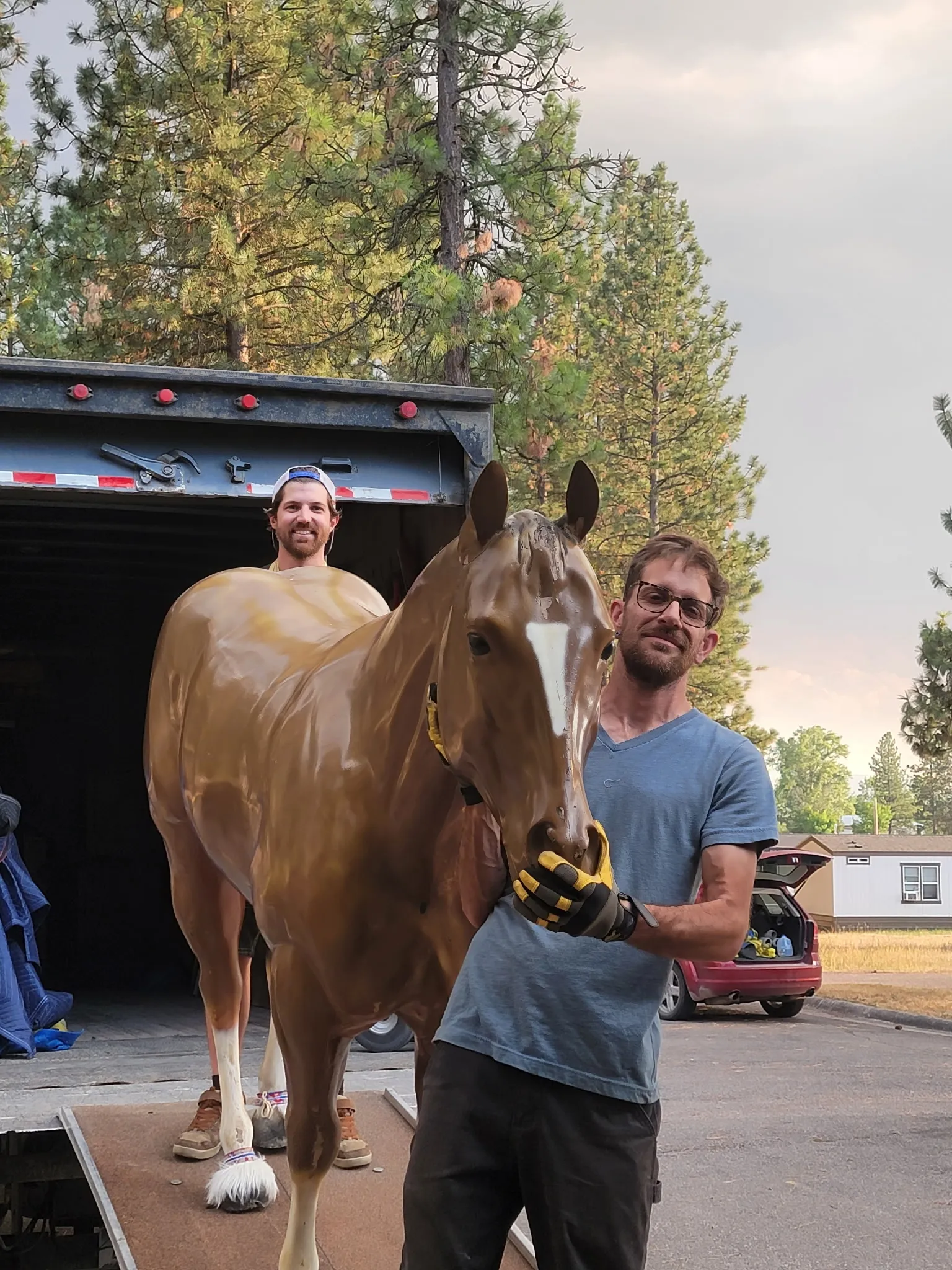 Crew loading a life-size horse statue into the moving trailer