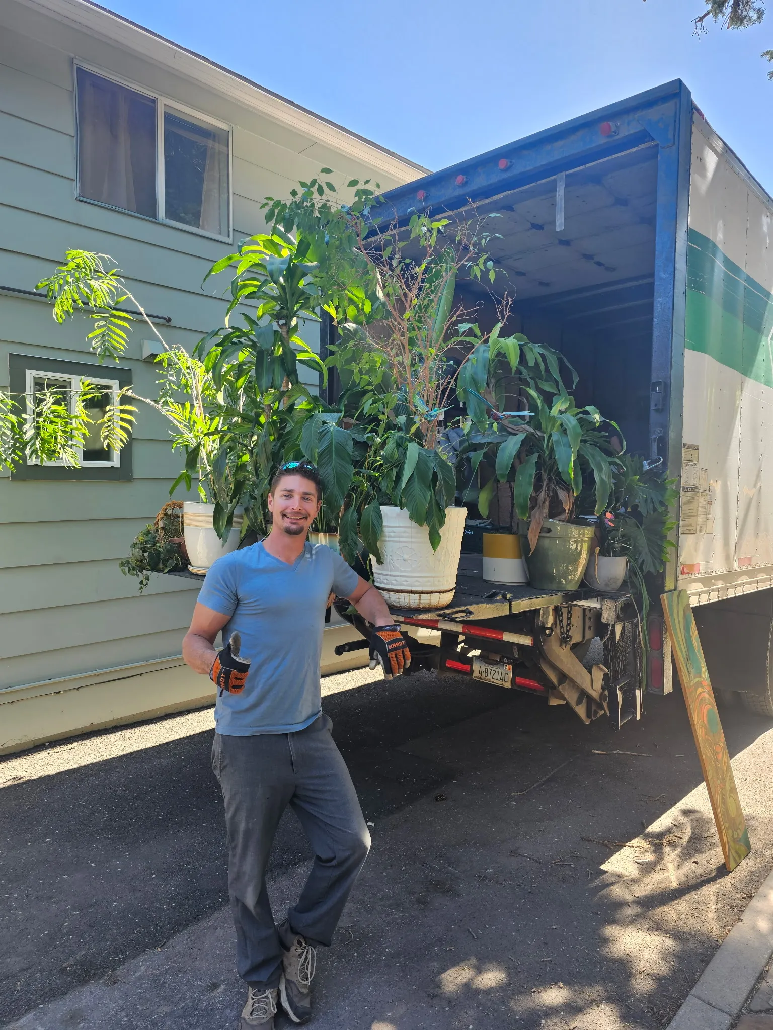 The owner of Moving On Up in front of a loaded moving truck.