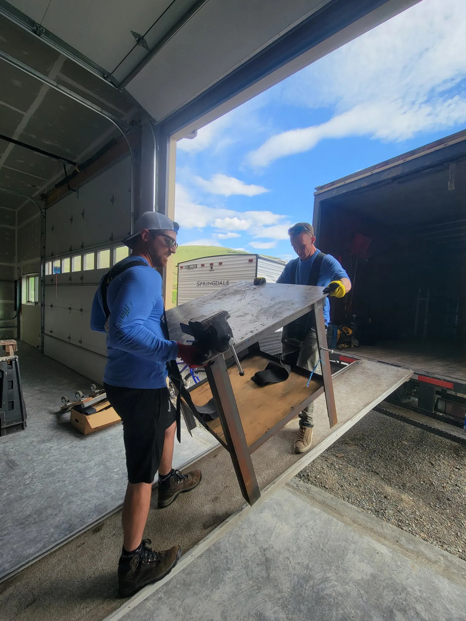 Moving On Up crew loading a glass-top table at a Missoula home